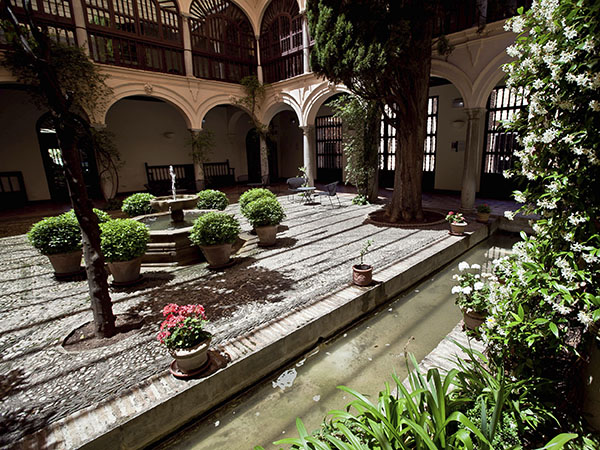 Interior of the cloister of the former convent, now a Parador Nacional hotel, with a section of the Royal Water Channel, around which the so-called Infantes’ Garden in the old Nasrid palace is laid out